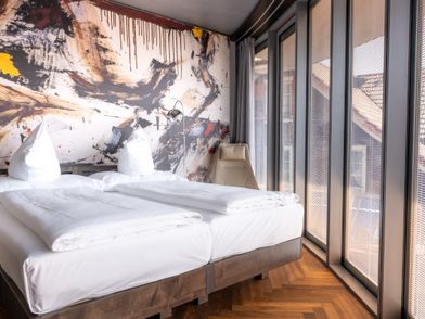 Hotelzimmer in Oberkirch Luzern, mit Doppelbett und Aussicht aus dem Fenster.